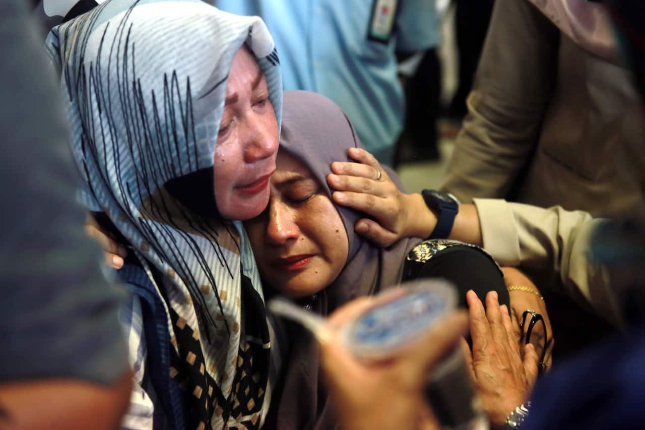Indonesian relatives of the plane crash victims cry as they wait for the news at the airport in Pangkal Pinang, Indonesia.
