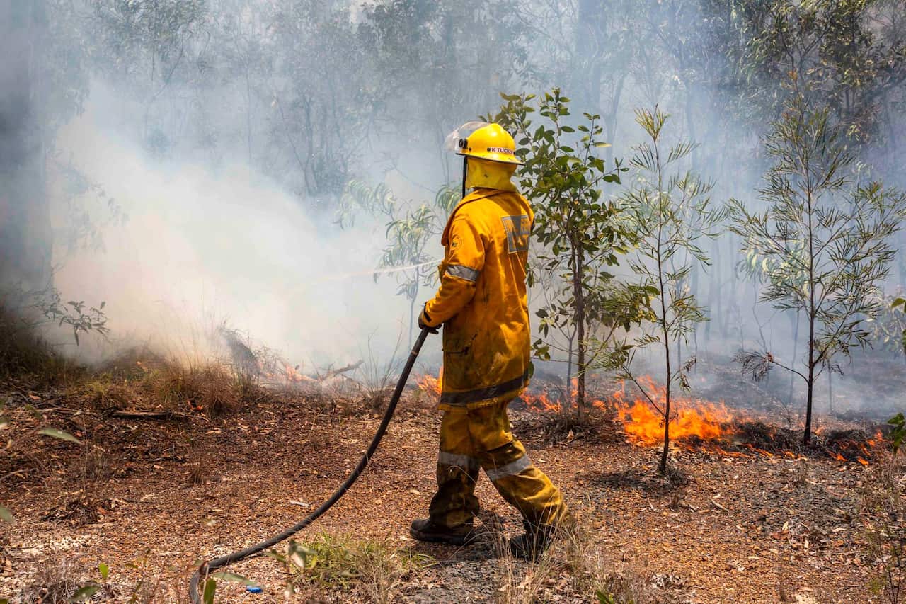 In this Nov. 2018, photo released on Wednesday, Nov. 28, 2018, by the Queensland Fire and Emergency Service, a firefighter works on a fire ground at Deepwater, near Bundaberg, Australia.