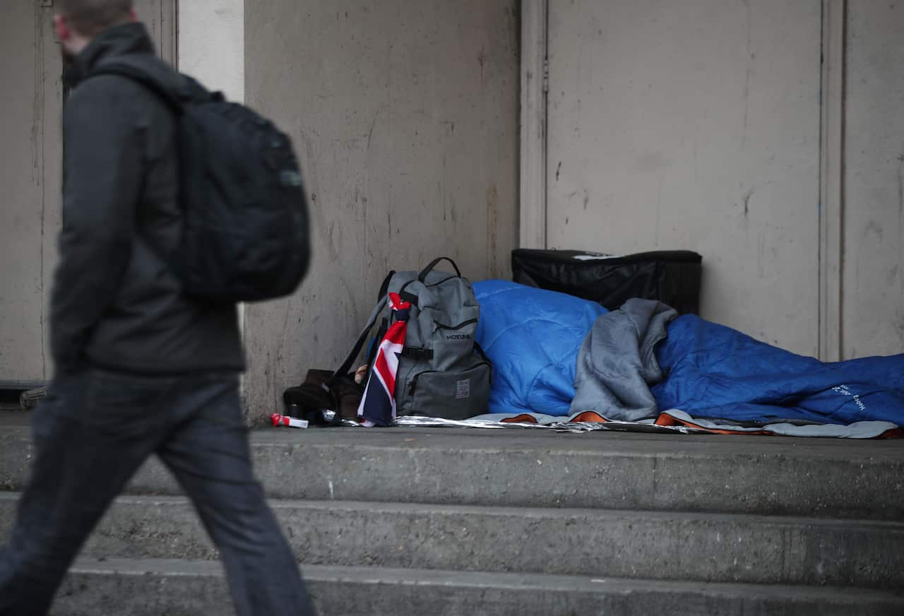  A person sleeping rough in a doorway. 