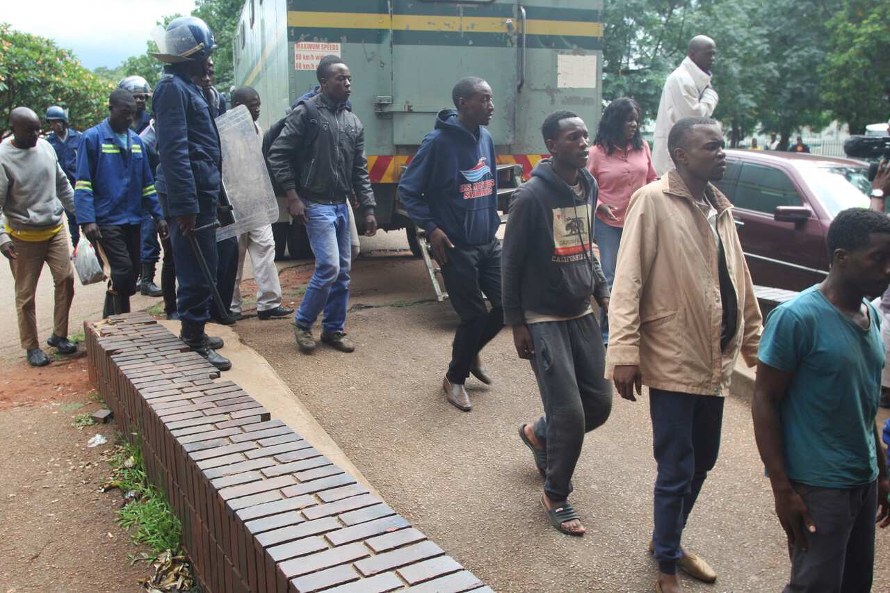  A policeman stands guard as some of the people arrested during  demonstrations over the hike in  fuel prices.