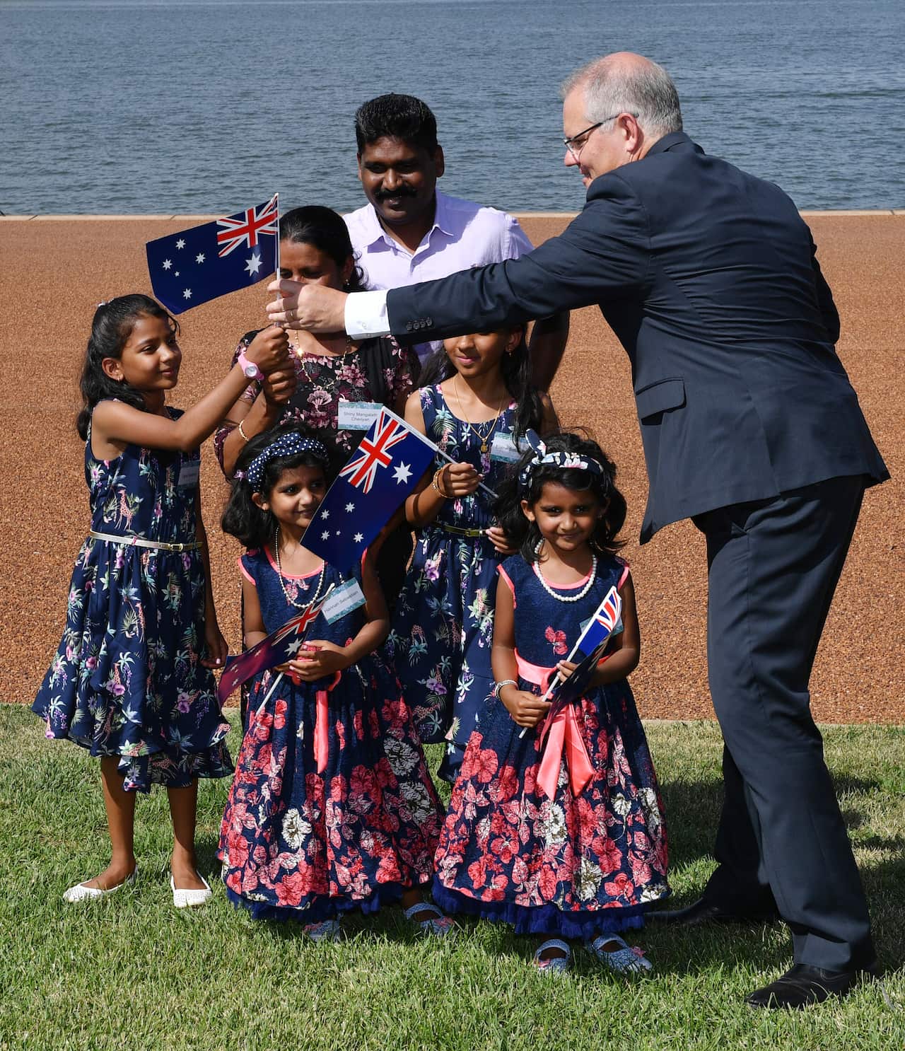 Prime Minister Scott Morrison hands out Australian flags to members of the Sebastien Family (originally from India).