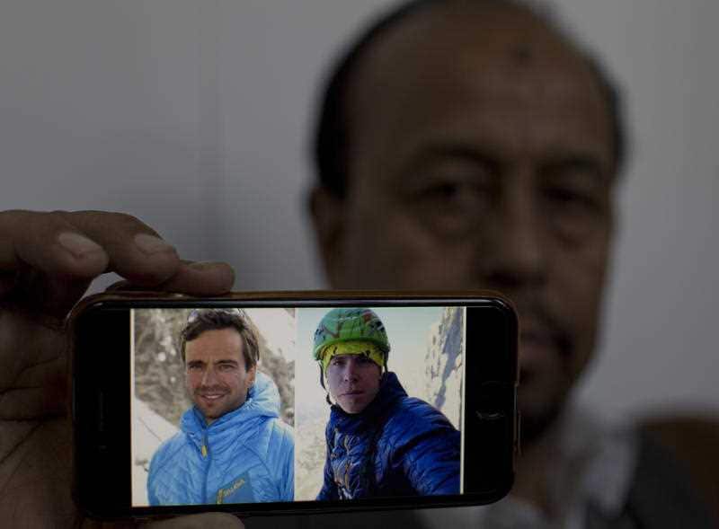 Karrar Haidri, secretary of the Alpine Club of Pakistan shows pictures of two missing climbers