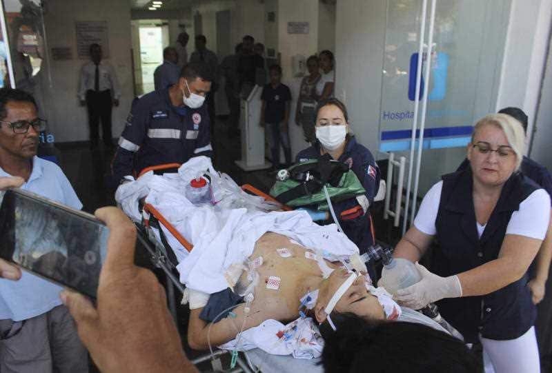 A teenager who was injured during the shooting is carried into hospital.