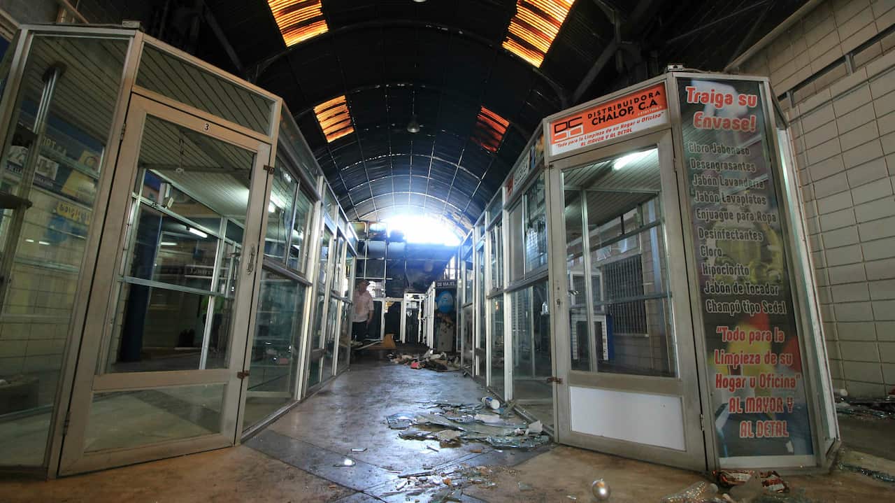 The hallway of a mall is trashed after stores stand empty one day after it was looted in Maracaibo