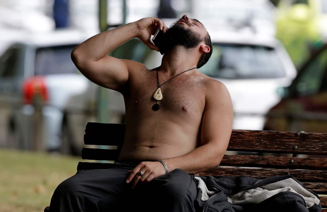 A man reacts as he speaks on a mobile phone outside a mosque in central Christchurch, New Zealand.