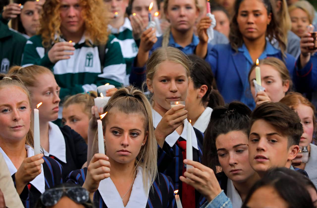 Students raise candles as they gather for a vigil to commemorate victims of Friday's shooting, outside the Al Noor mosque in Christchurch, New Zealand.