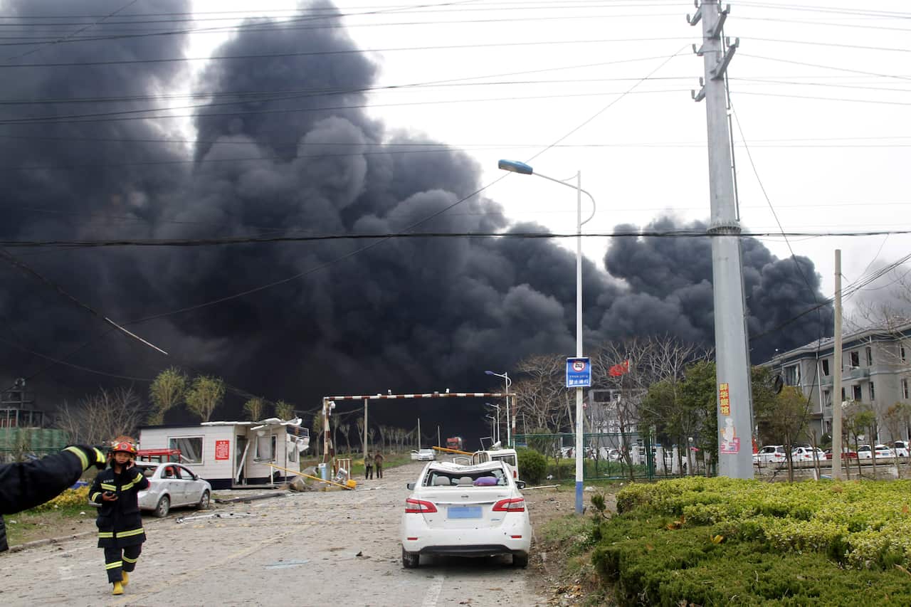 Firefighters walk past the site of a factory explosion in a chemical industrial park in Xiangshui County of Yancheng in  eastern China's Jiangsu province.