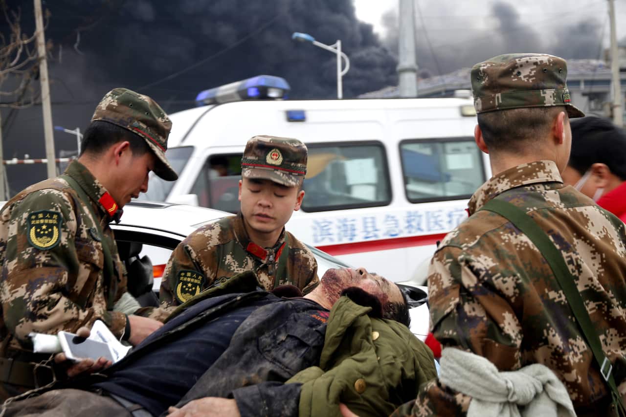 An injured person is helped by rescuers near the site of an explosion at a chemical industrial park in Xiangshui county, in east China's Jiangsu province.