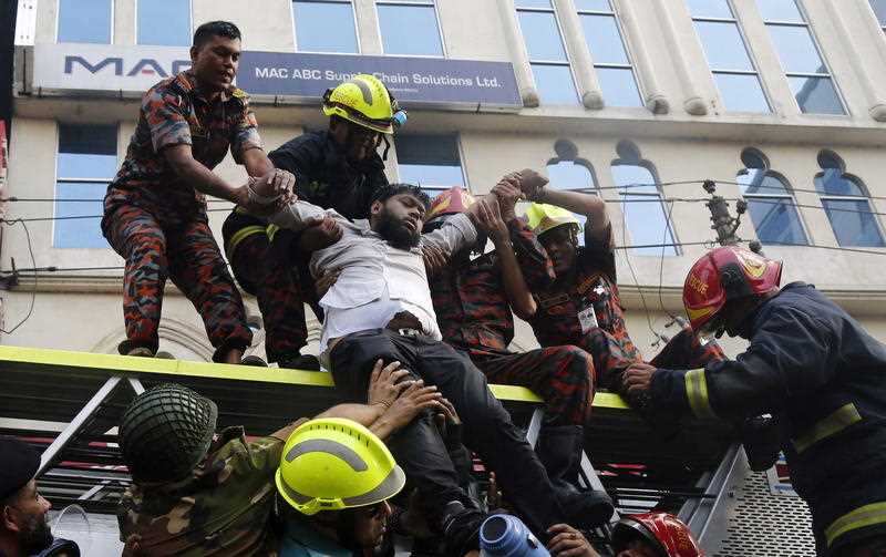 Firefighters rescue a victim from the burning high-rise building in Banani area of Dhaka