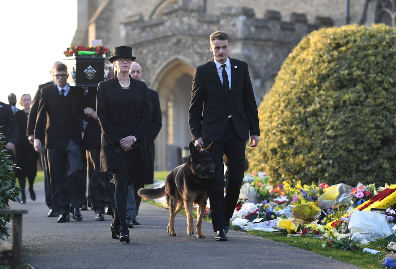 The coffin of Keith Flint leaves St Mary's Church in Bocking, Essex, with his dog, Cyrus in front.