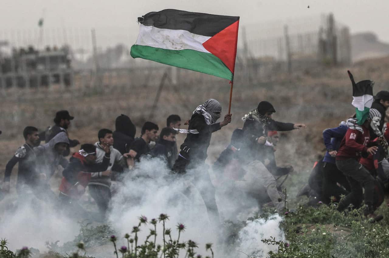 Palestinian protesters run for cover