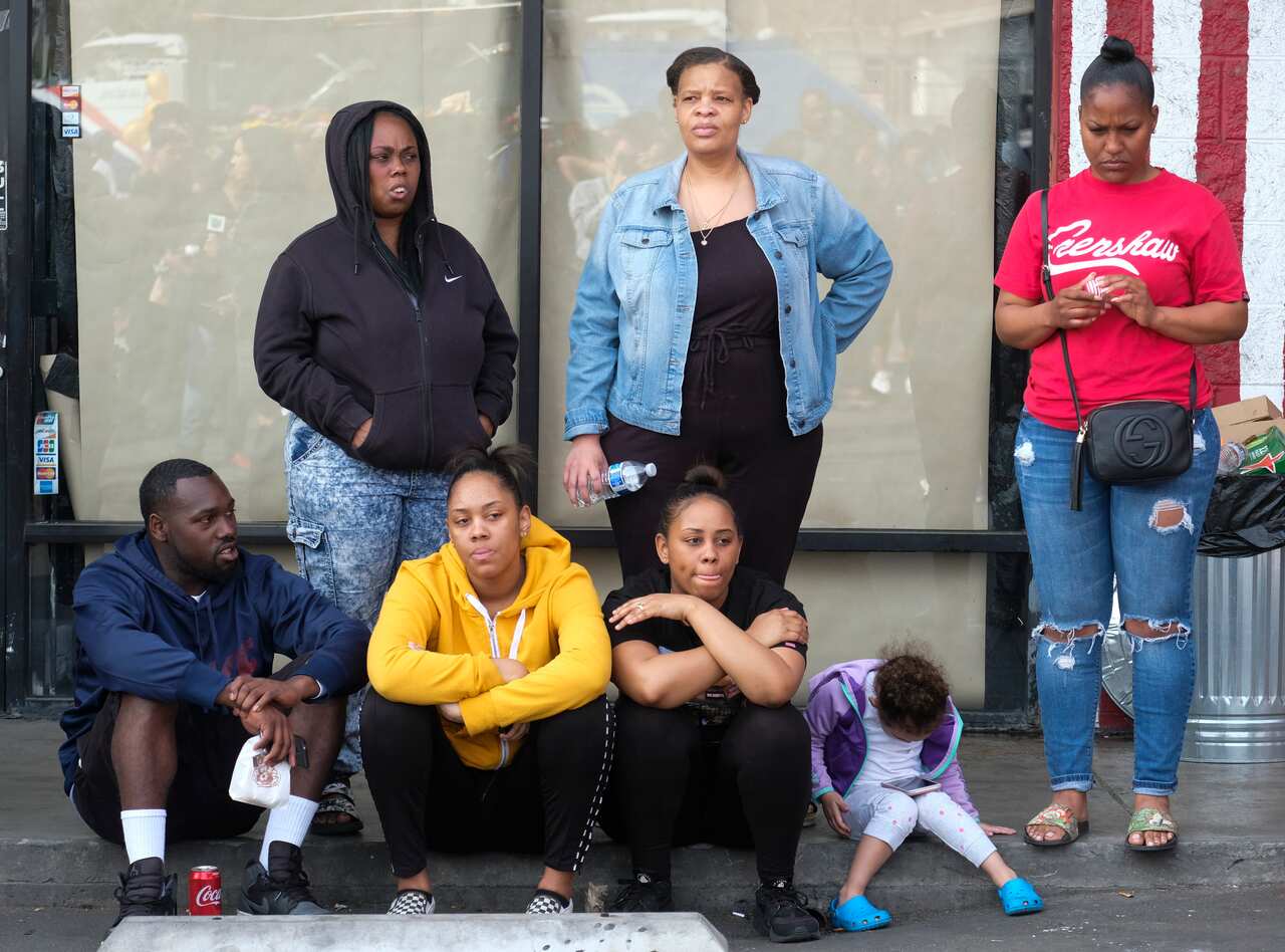 Fans of rapper Nipsey Hussle appear at a makeshift memorial in the parking lot of Hussle's Marathon Clothing store in Los Angeles, Monday, April 1, 2019. Hussle was killed in a shooting outside the clothing store on Sunday. (AP Photo/Ringo H.W. Chiu)
