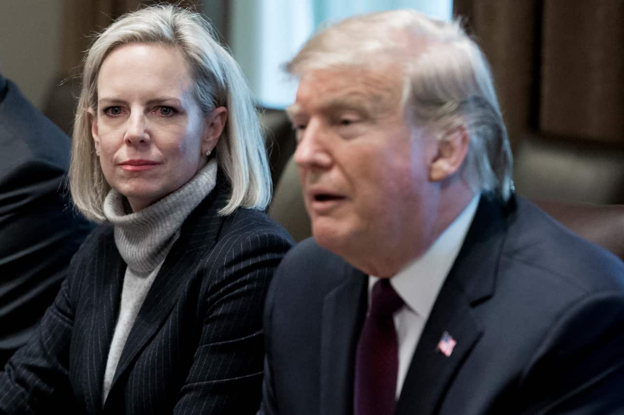 US Secretary of Homeland Security Kirstjen Nielsen (L) listens to US President Donald J. Trump (R).