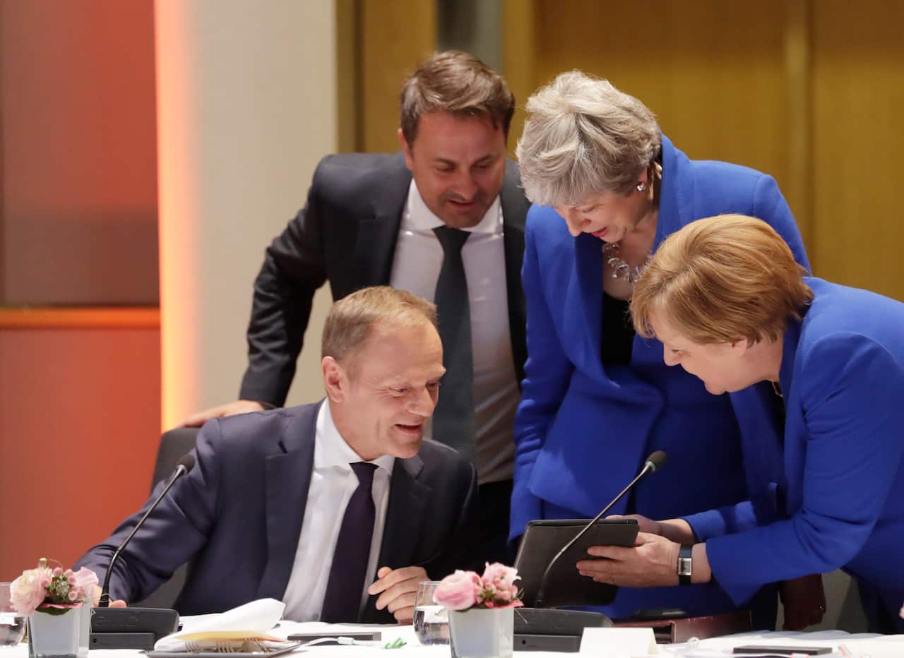 European Council President Donald Tusk, left, speaks with British Prime Minister Theresa May, center right, German Chancellor Angela Merkel, right.