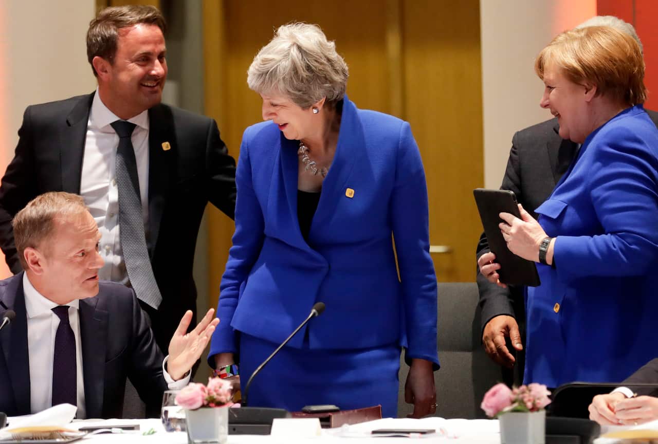European Council President Donald Tusk, left, speaks with British Prime Minister Theresa May, center, German Chancellor Angela Merkel, right.,