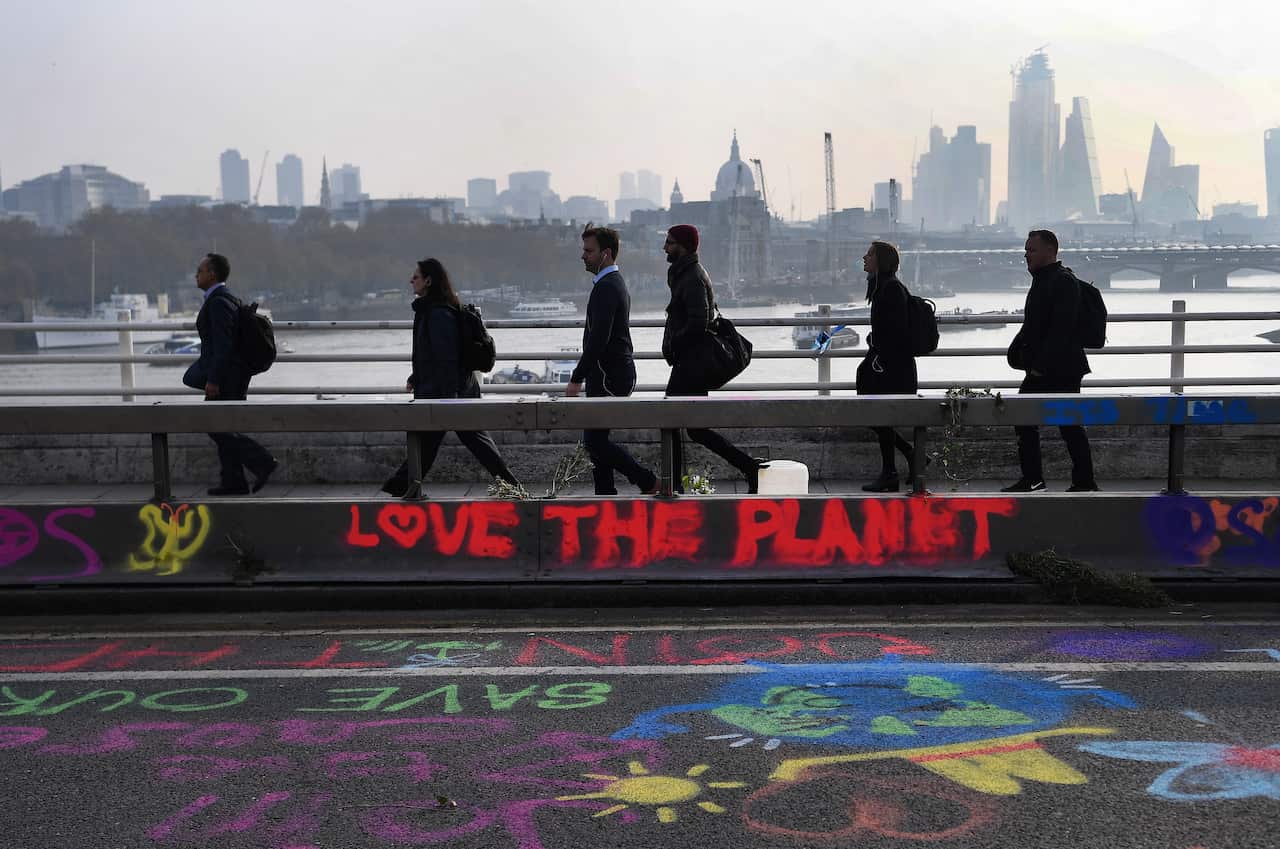 Pedestrians walk over Waterloo Bridge during climate change protests in London, Britain, 16 April 2019.