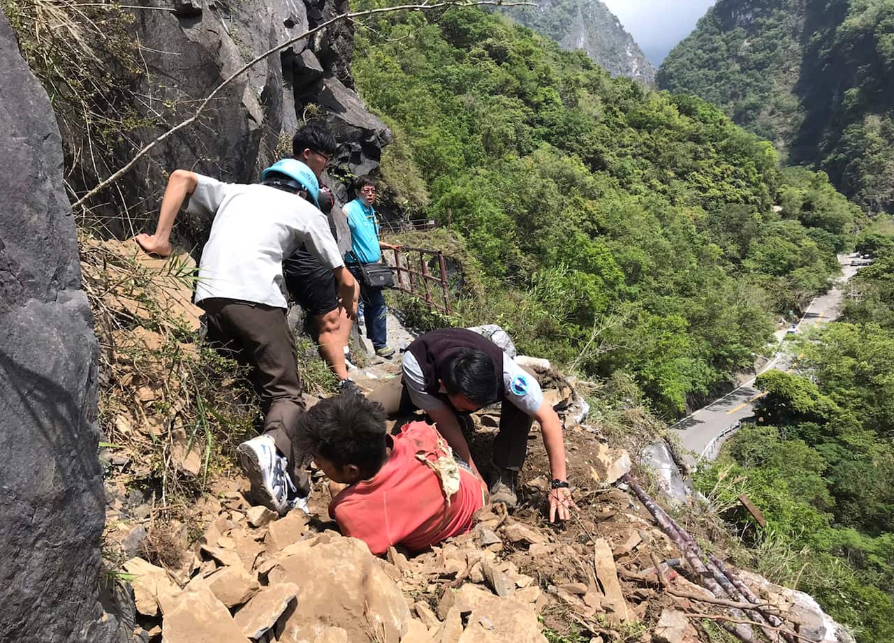 An injured Malaysian tourist is assisted by rescue workers at the Taroko National Park after a strong 6.1 magnitude earthquake struck Taiwan's east coast.