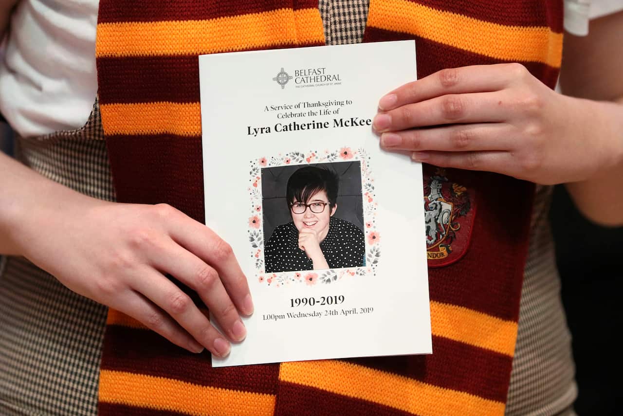 A mourner wearing a Gryffindor scarf holds an order of service as she arrives for the funeral of murdered journalist Lyra McKee.