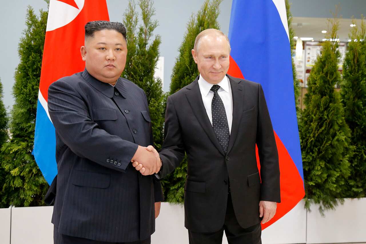 Russian President Vladimir Putin and North Korea's leader Kim Jong-un shake hands.