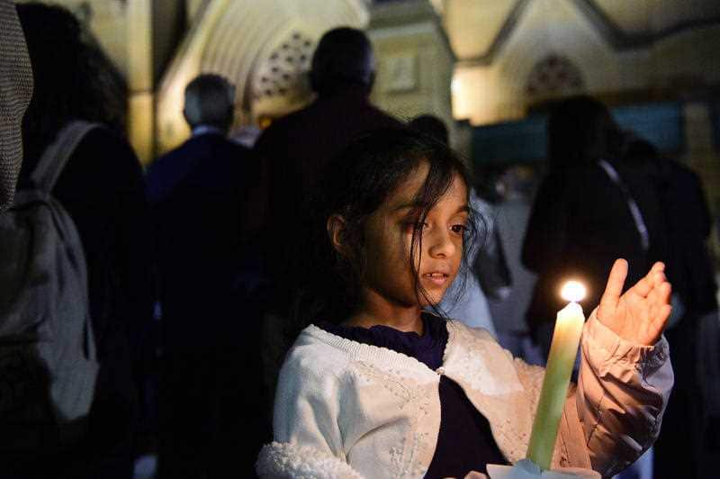 Saminie Ratnaweera, 6, joins in on the interfaith candlelight vigil.