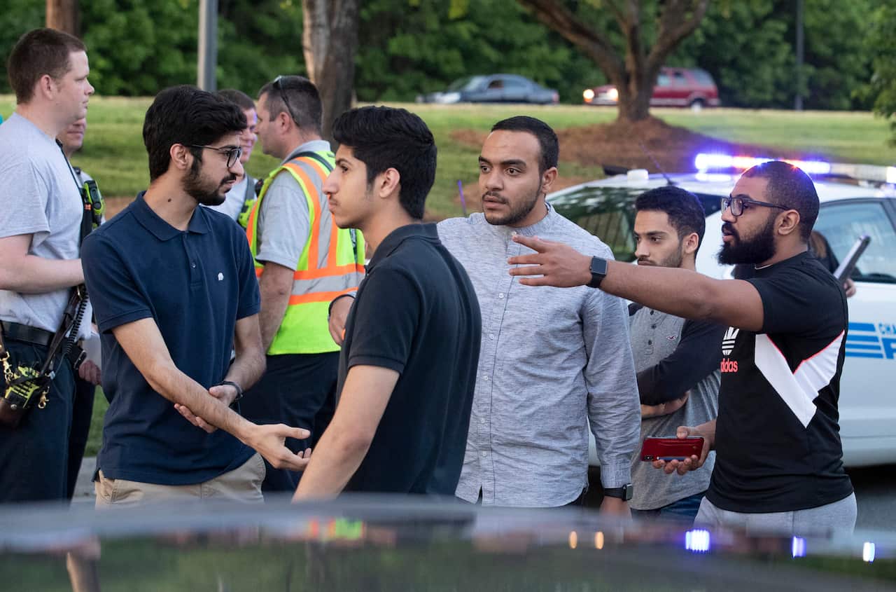 People gather across from the campus of University of North Carolina at Charlotte.