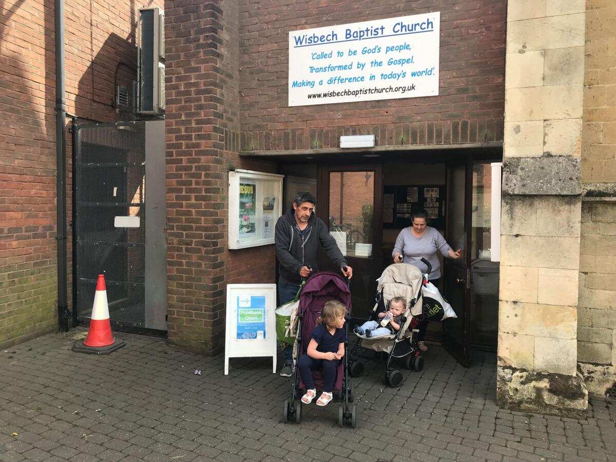 A couple and their two children leave the food bank in Wisbech, Cambridgeshire, after collecting a three day emergency supply of food, April 2019.