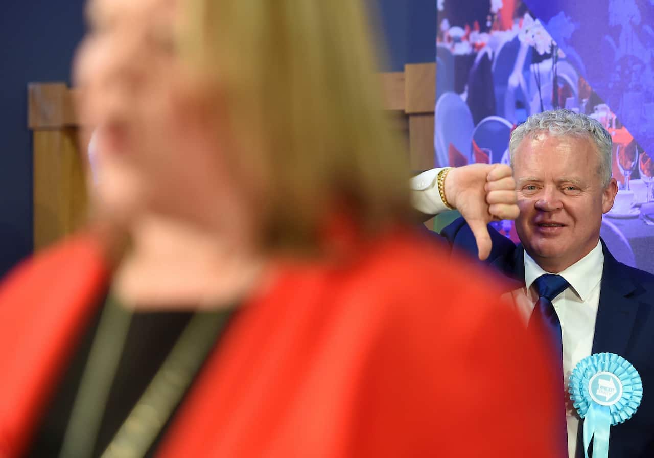 Brexit Party candidate Mike Greene gives a thumbs down as newly elected Labour MP Lisa Forbes gives her winners speech.