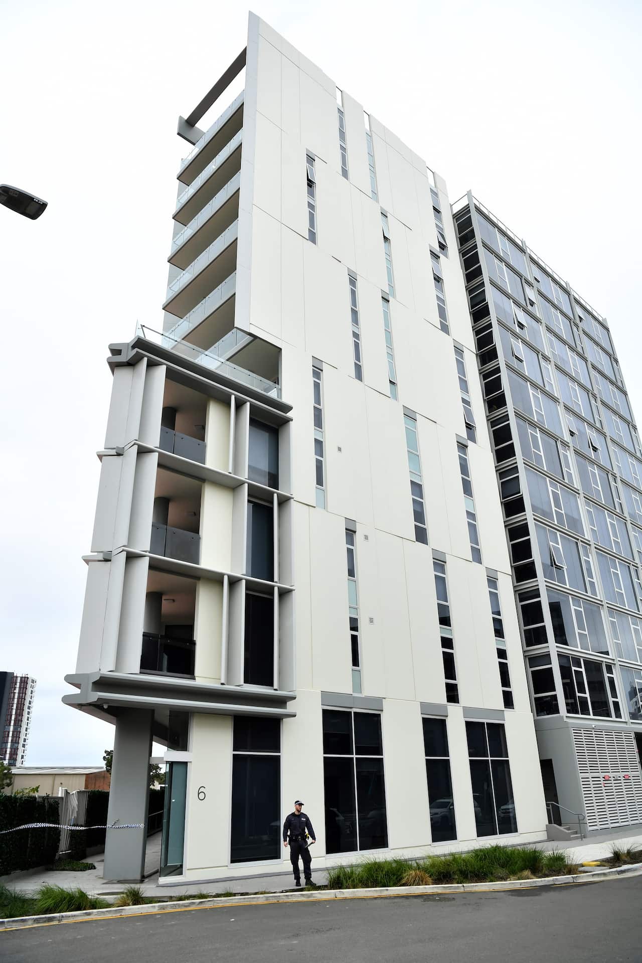 The 23-year-old was discovered on a footpath at the back of the 11-storey complex.