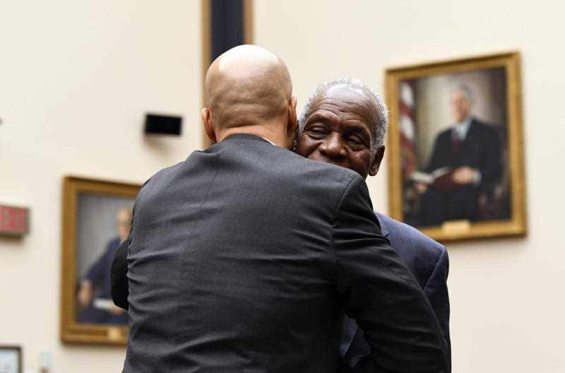 Sen. Cory Booker, D-N.J., greets actor and activist Danny Glover as he arrives to testify 
