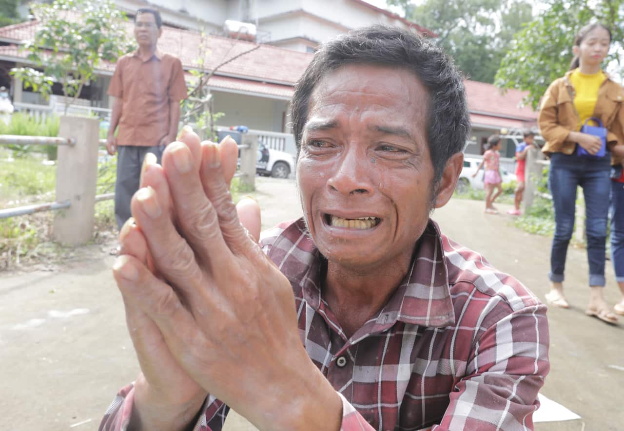 A Cambodian man prays for his daughter who died in a building collapse 