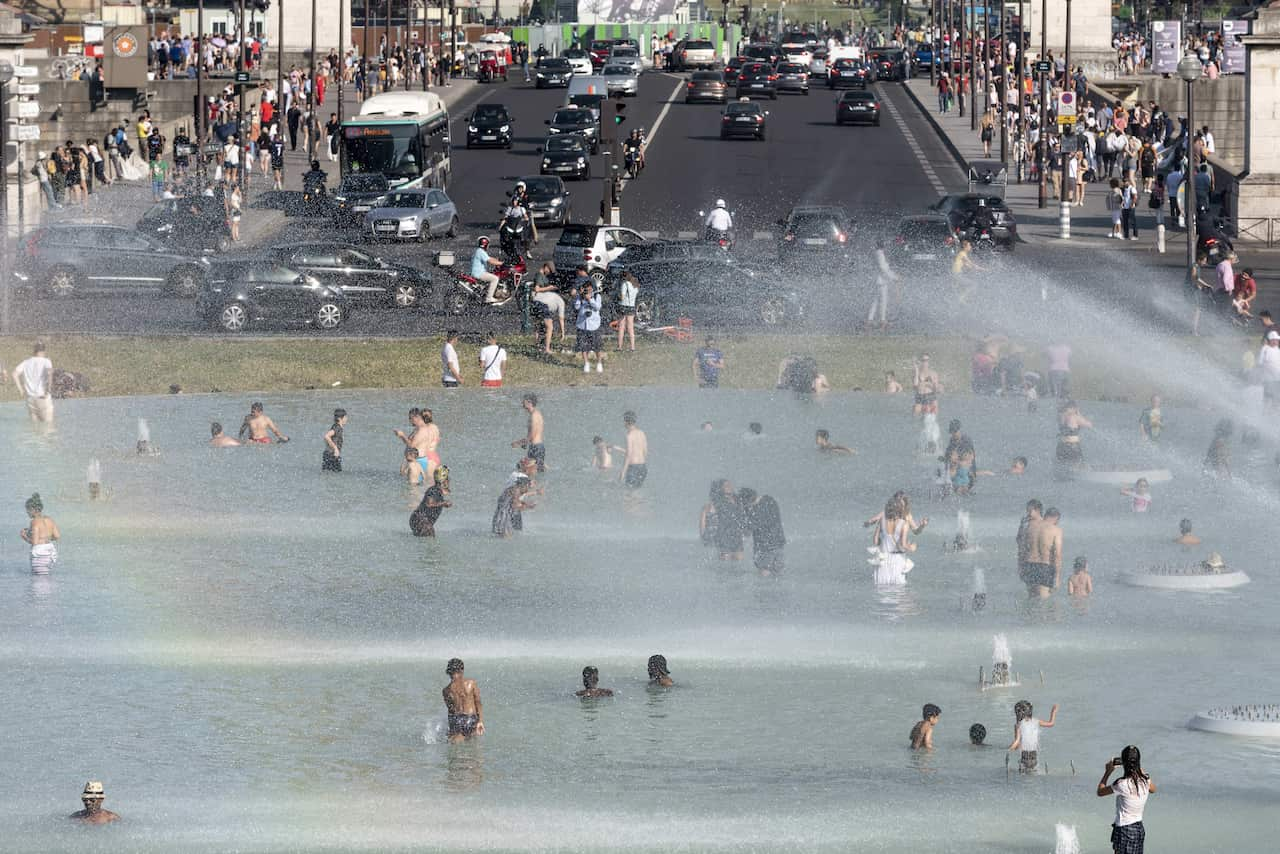 People cool themselves down in the fountain of the Trocadero esplanade in Paris, France.