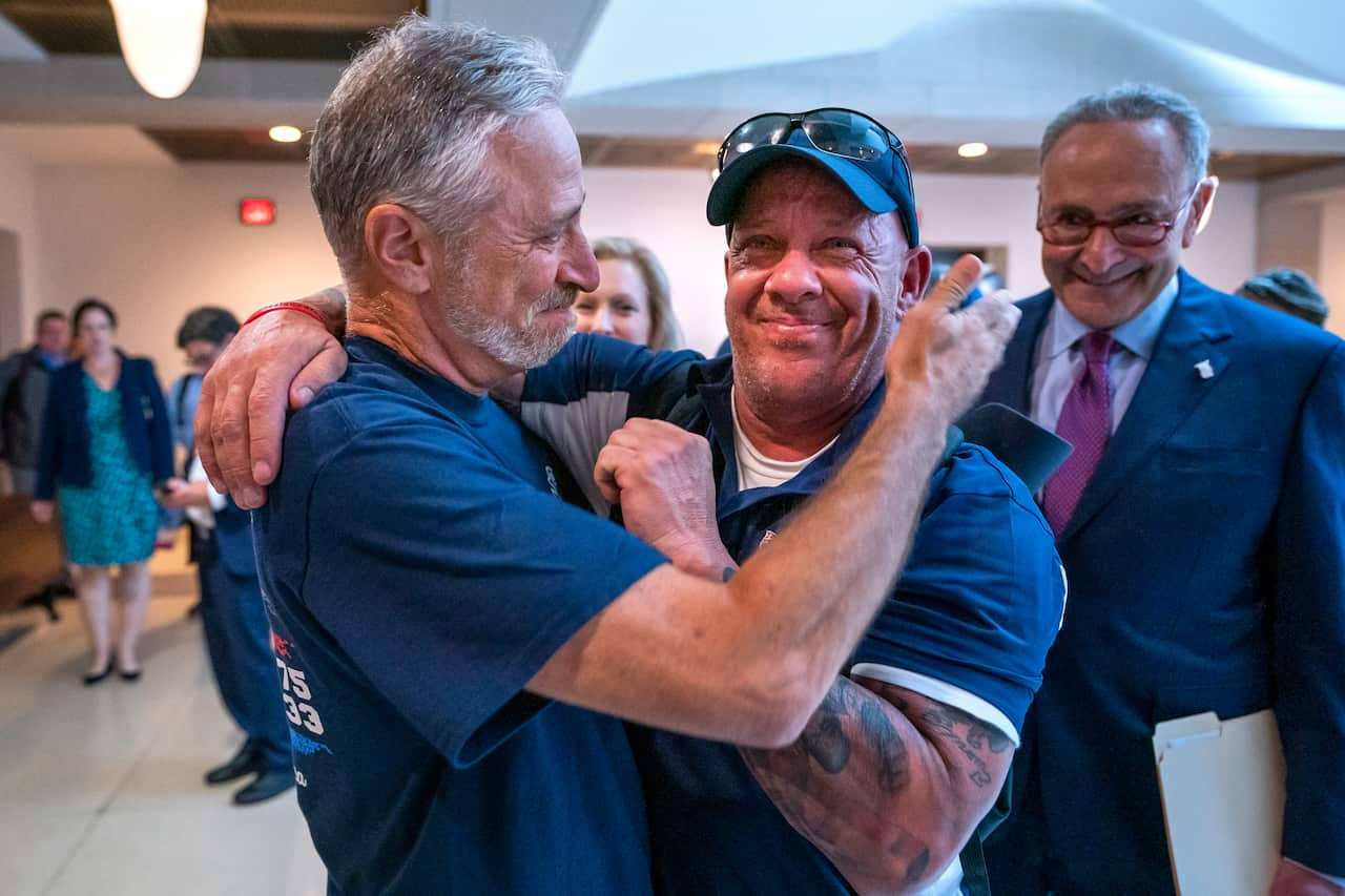 Former 'Daily Show' host Jon Stewart, who championed the bill, embraces 9/11 first responder John Feal. 