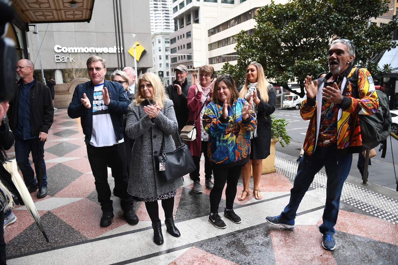 Supporters, including Mark and Faye Leveson applaud as Former NSW Detective Gary Jubelin arrives at Down Centre Courts in Sydney.