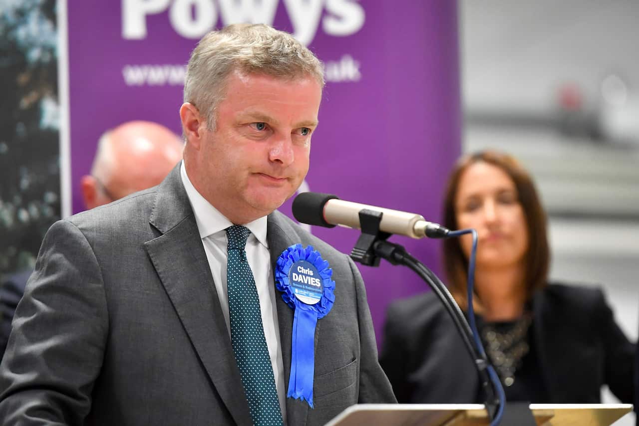 Conservative Chris Davies speaks on stage as Liberal Democrats MP Jane Dodds looks on after winning the seat in the Brecon and Radnorshire by-election.
