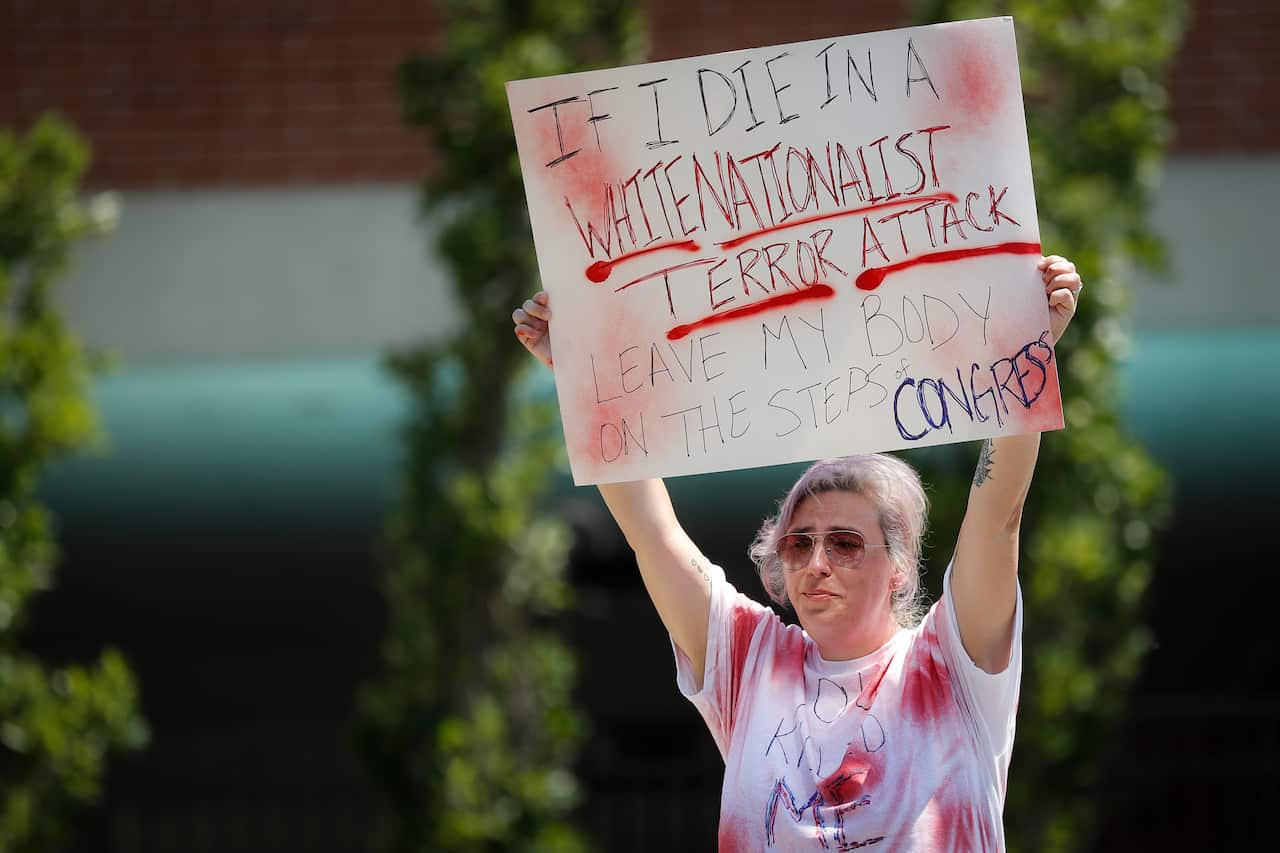 Mourner Amanda Luke holds a sign at vigil following the mass shooting in Dayton, Ohio.