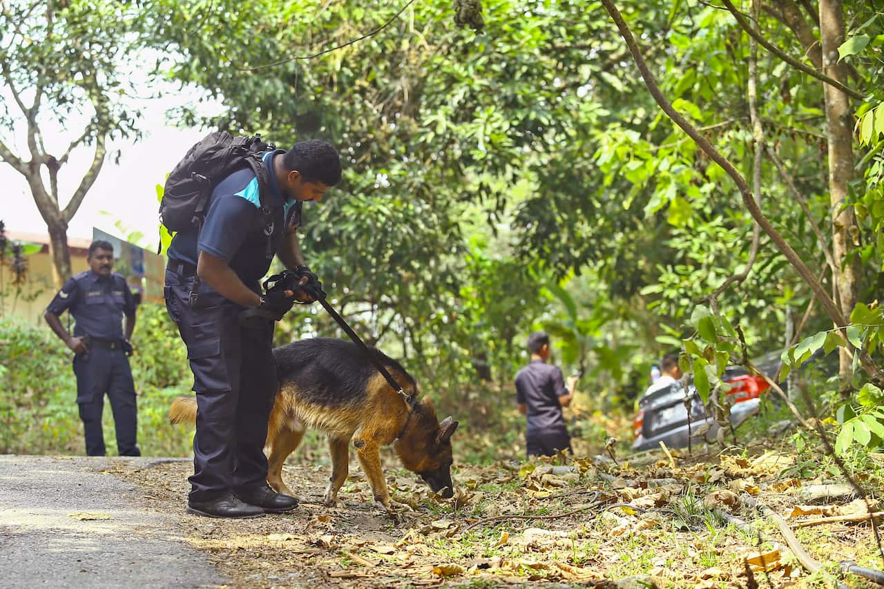 A K9 Unit officer from the Royal Malaysian Police takes part in the search for 15-year-old Nora Quoirin.