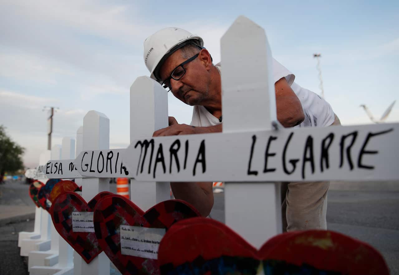 Greg Zanis prepares crosses to place at a makeshift memorial for victims of a mass shooting at a shopping complex Monday, Aug. 5, 2019, in El Paso, Texas. (AP Photo/John Locher)