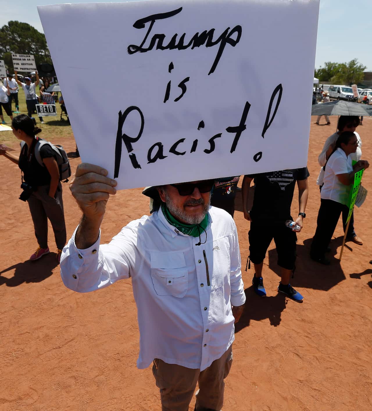 Protesters hold signs at a protest against US President Donald Trump's visit after the mass shooting that happened at a Walmart in El Paso, Texas.