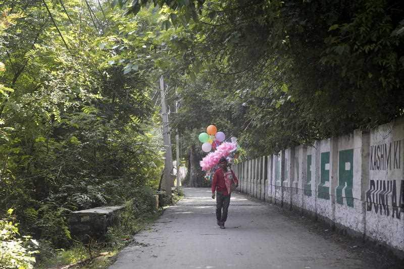 A migrant vendor walks to find customers in Srinagar, India, 11 August 2019. 