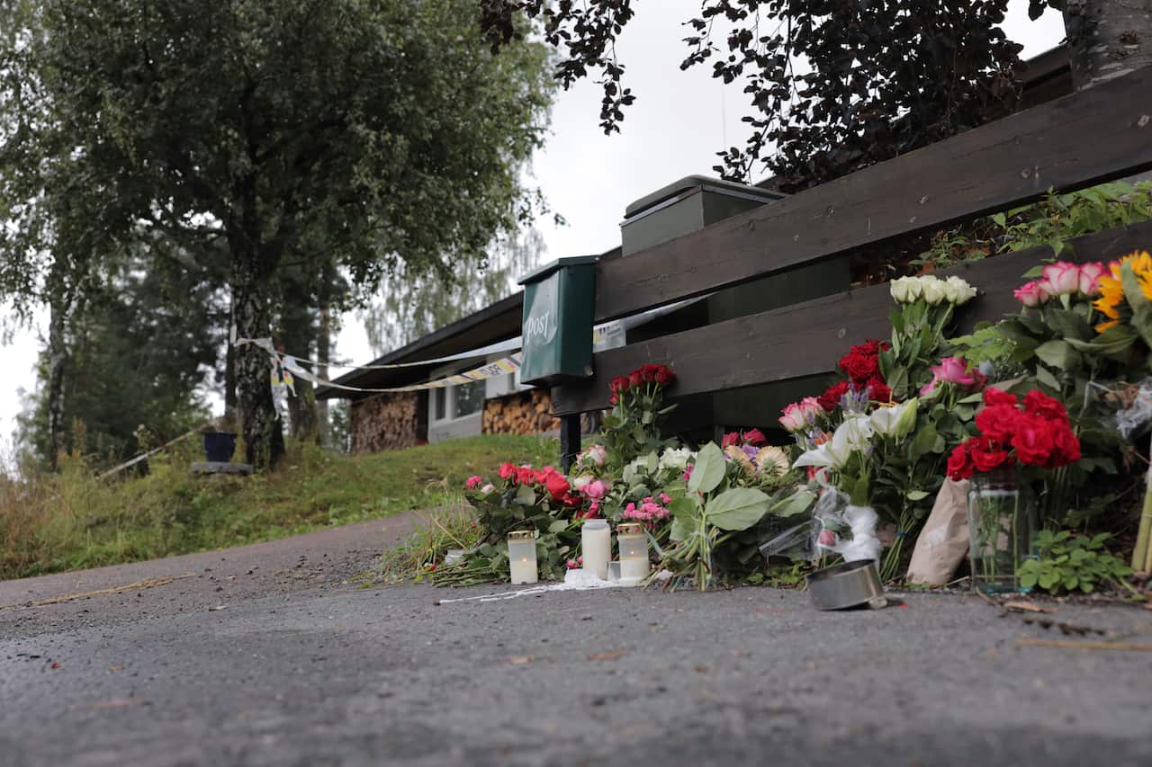 Flowers are left side of the house where the body of the stepsister of a suspected gunman was found, in Baerum, Norway, Monday Aug. 12, 2019