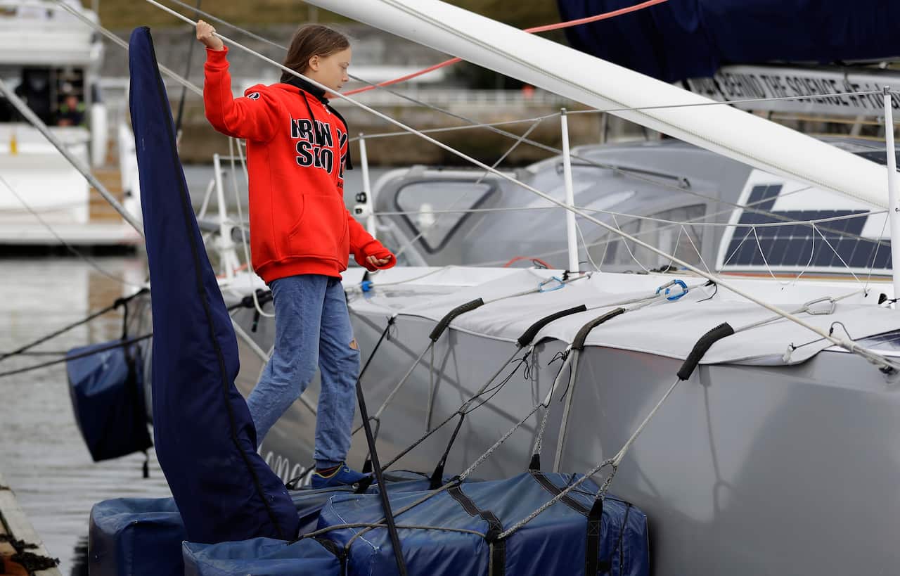 Greta Thunberg climbs onto the boat Malizia as it is moored in Plymouth, England Tuesday, Aug. 13, 2019.