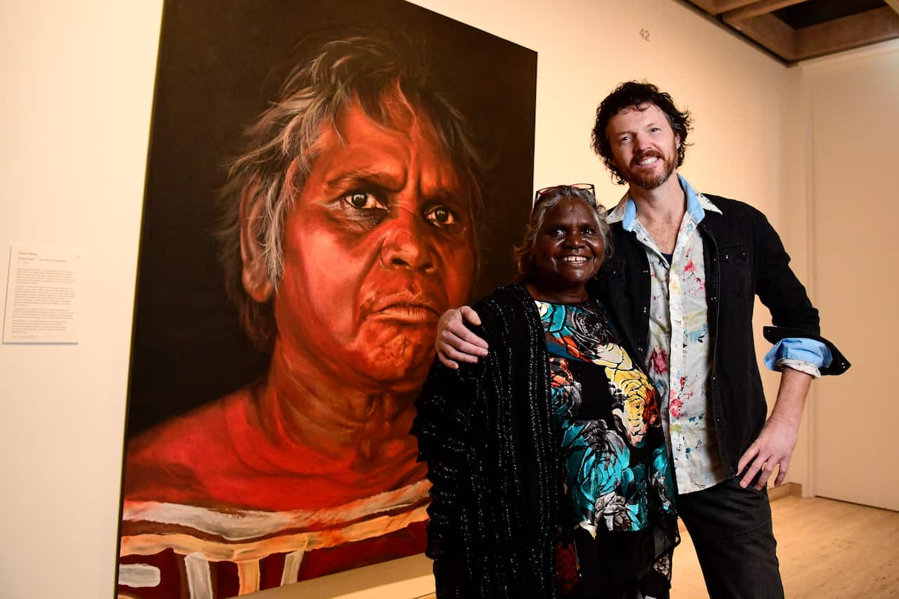 Aboriginal Elder Daisy Tjuparntarri Ward and artist David Darcy pose for a photograph in front of David's portrait of Daisy at the Art Gallery of NSW