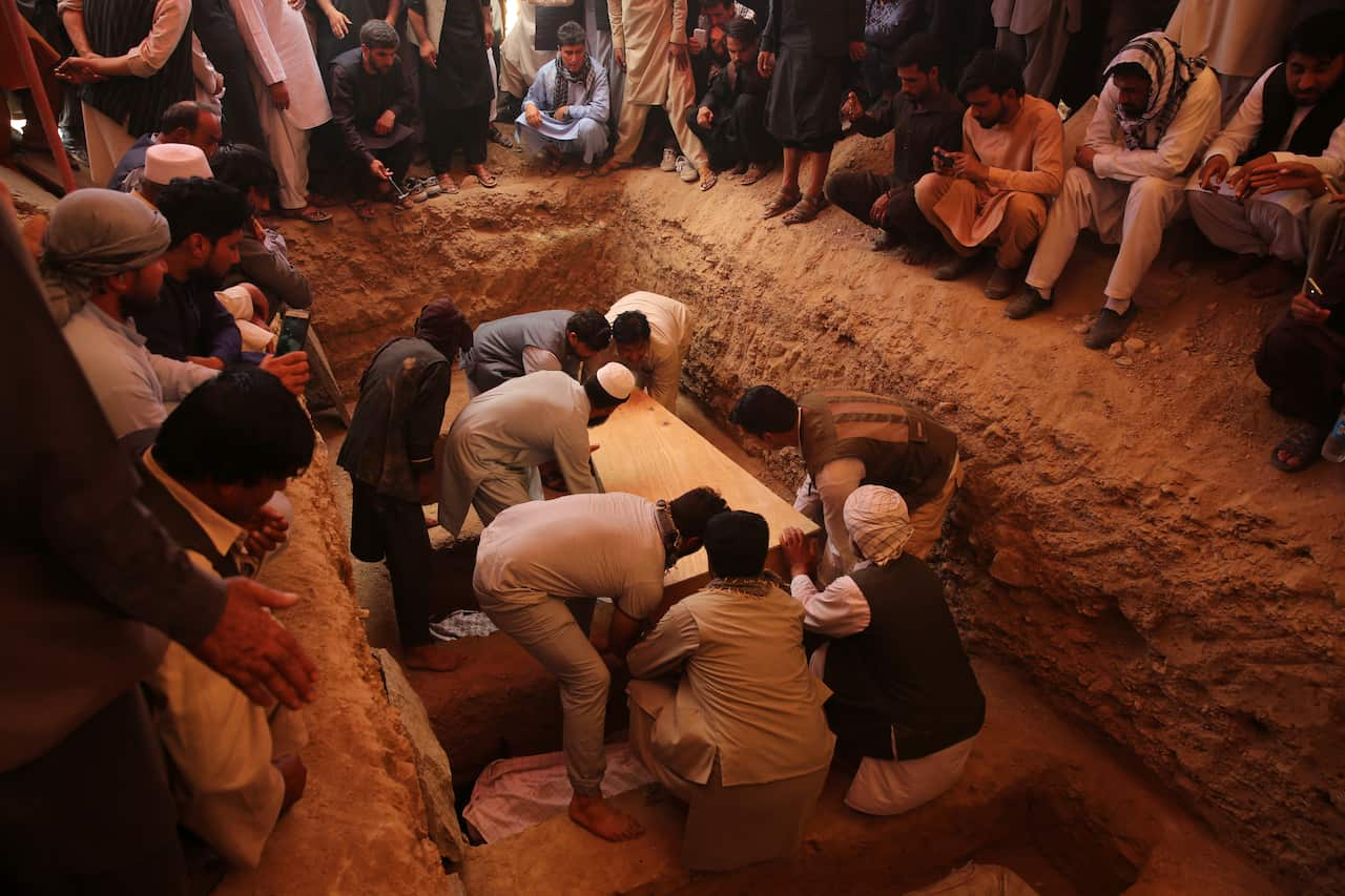 Afghans bury the bodies of victims of the Dubai City wedding hall bombing during a mass funeral in Kabul, Afghanistan, Sunday.