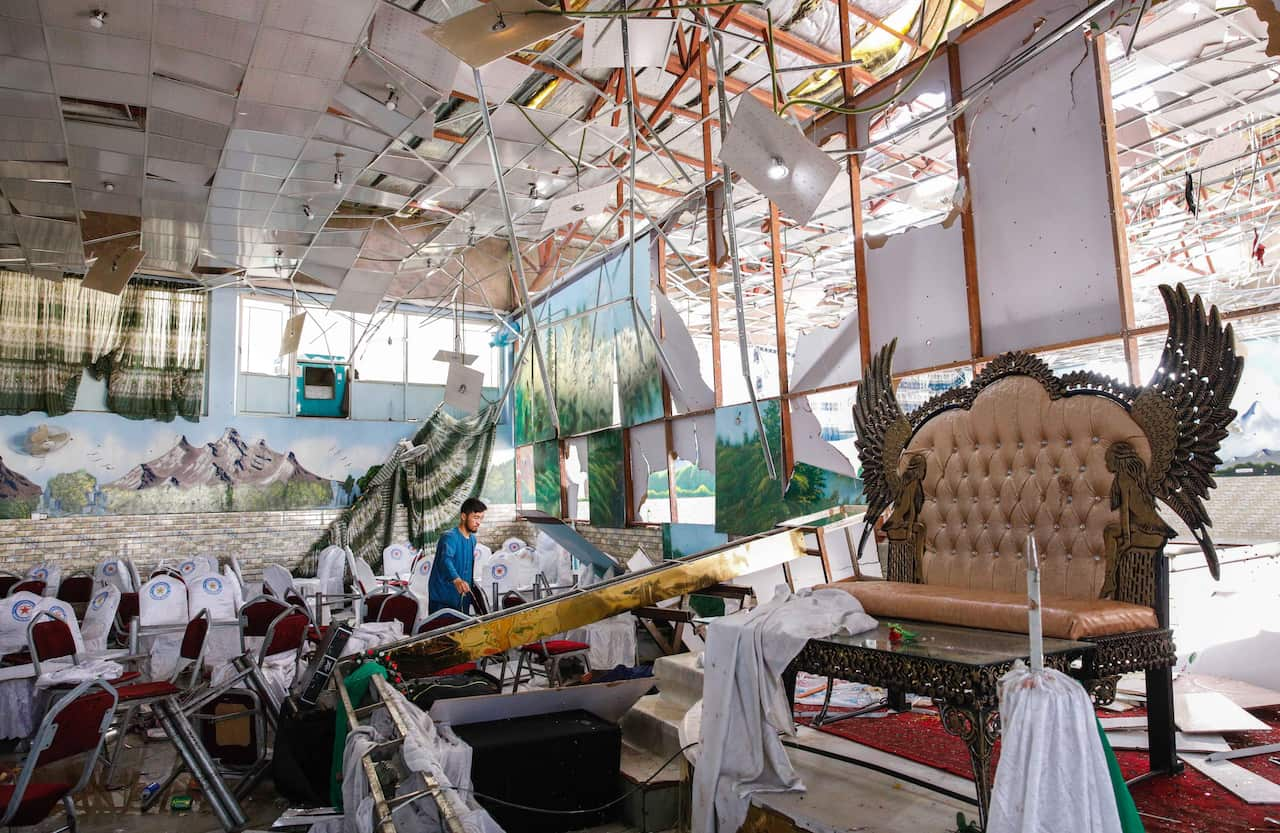 People survey the destruction after an overnight suicide bomb explosion that targeted a wedding reception in Kabul, Afghanistan.