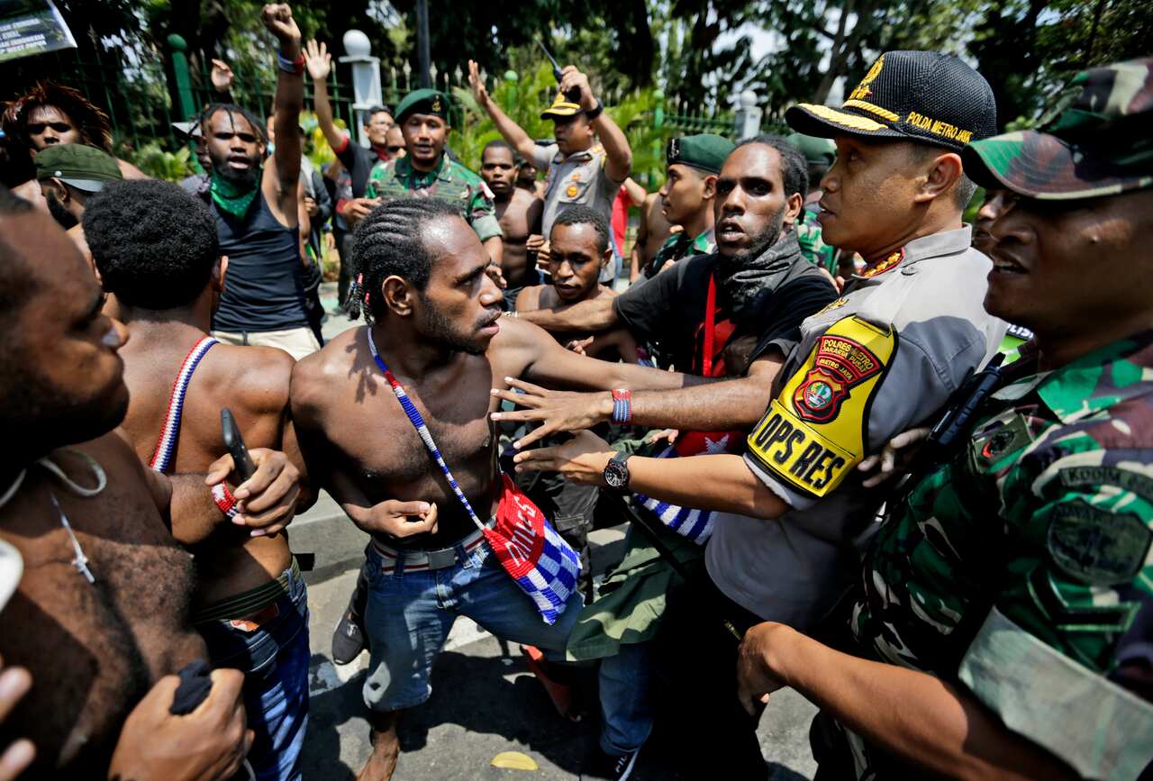 Papuan activists scuffle with police and soldiers during a rally near the presidential palace in Jakarta, Indonesia.