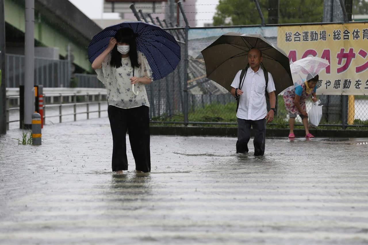 People wade through a flooded road on Wednesday.