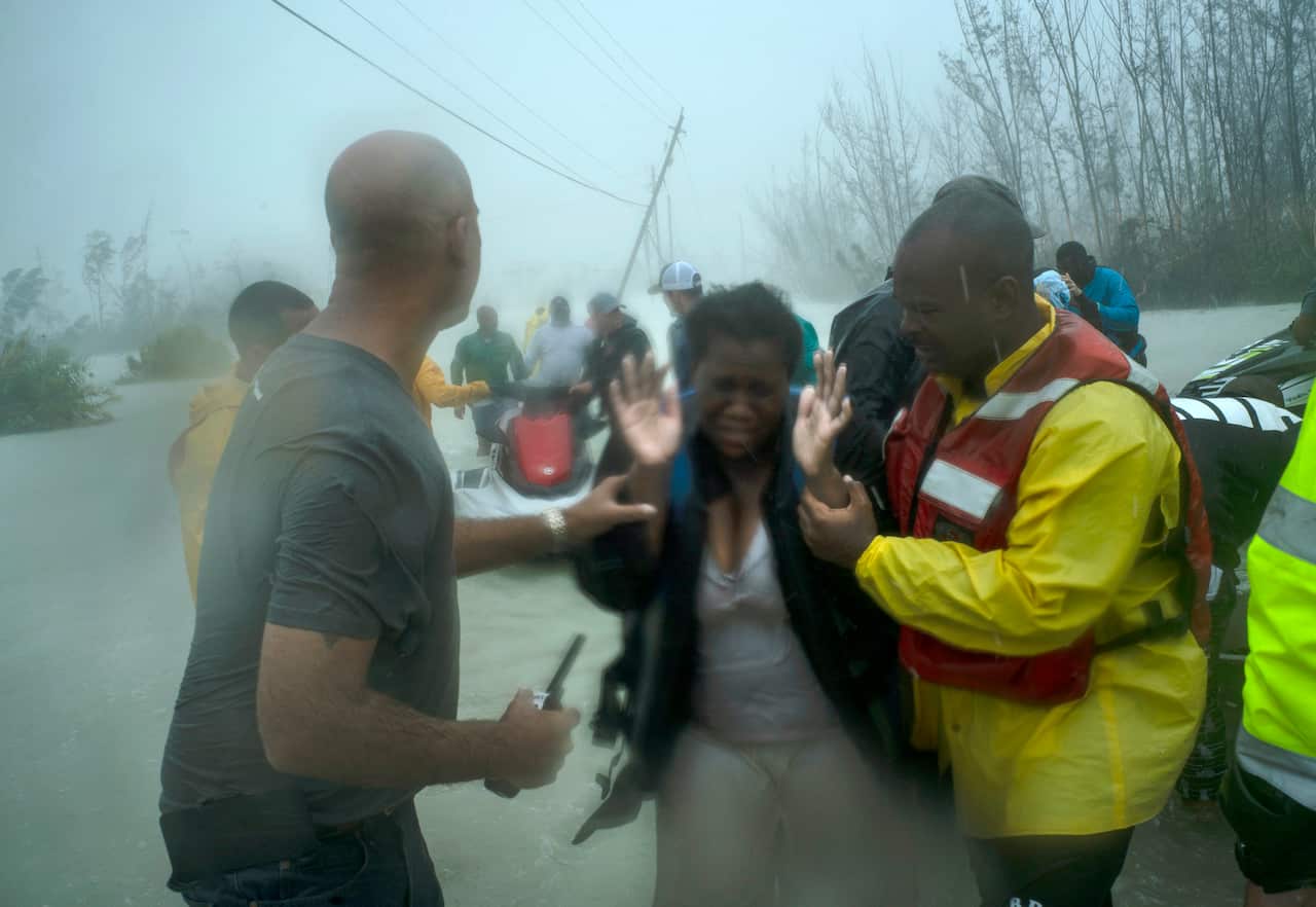 Volunteers rescue several families that arrived on small boats, from the rising waters of Hurricane Dorian