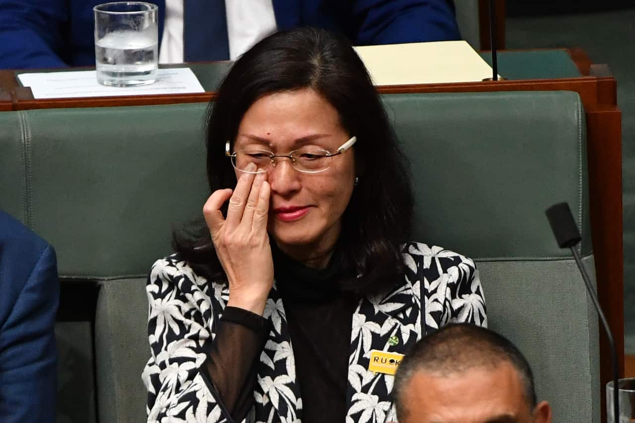 Liberal member for Chisholm Gladys Liu wipes away tears during Question Time in the House of Representatives at Parliament House in Canberra.