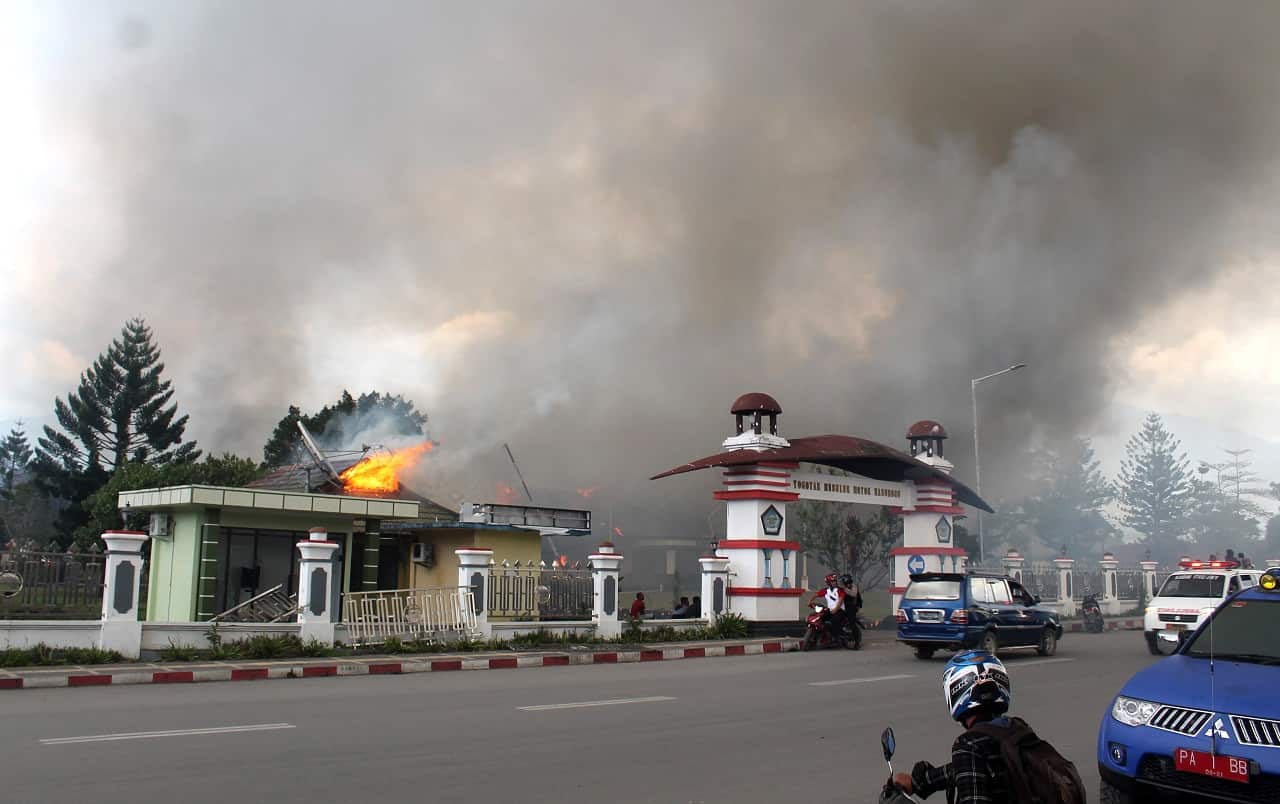 Smoke rise from a burning building during a violent rally in Wamena on Monday.