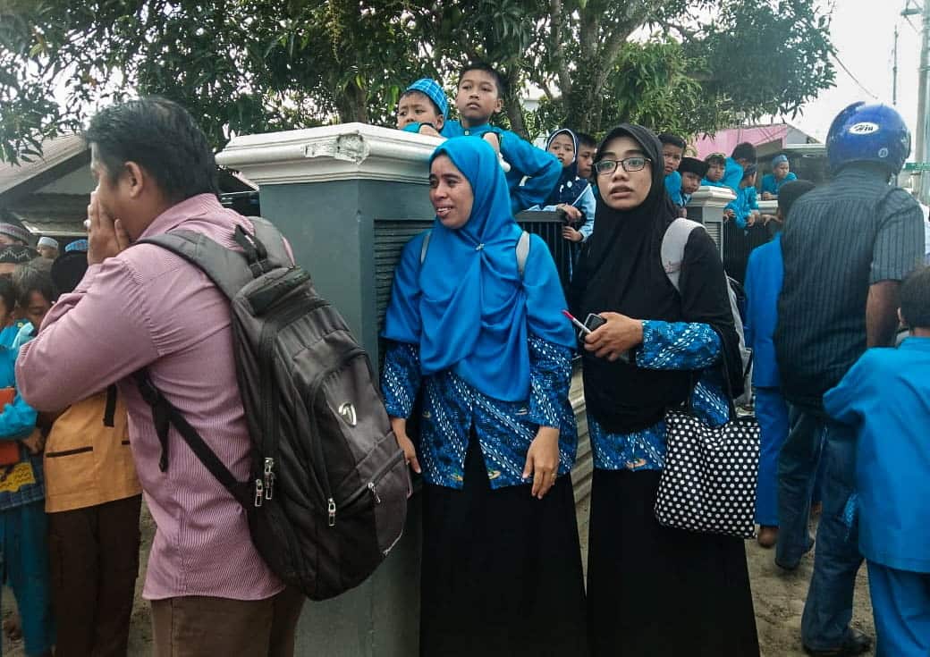 Hundreds of residents run outside buildings shortly after an earthquake in Ambon,